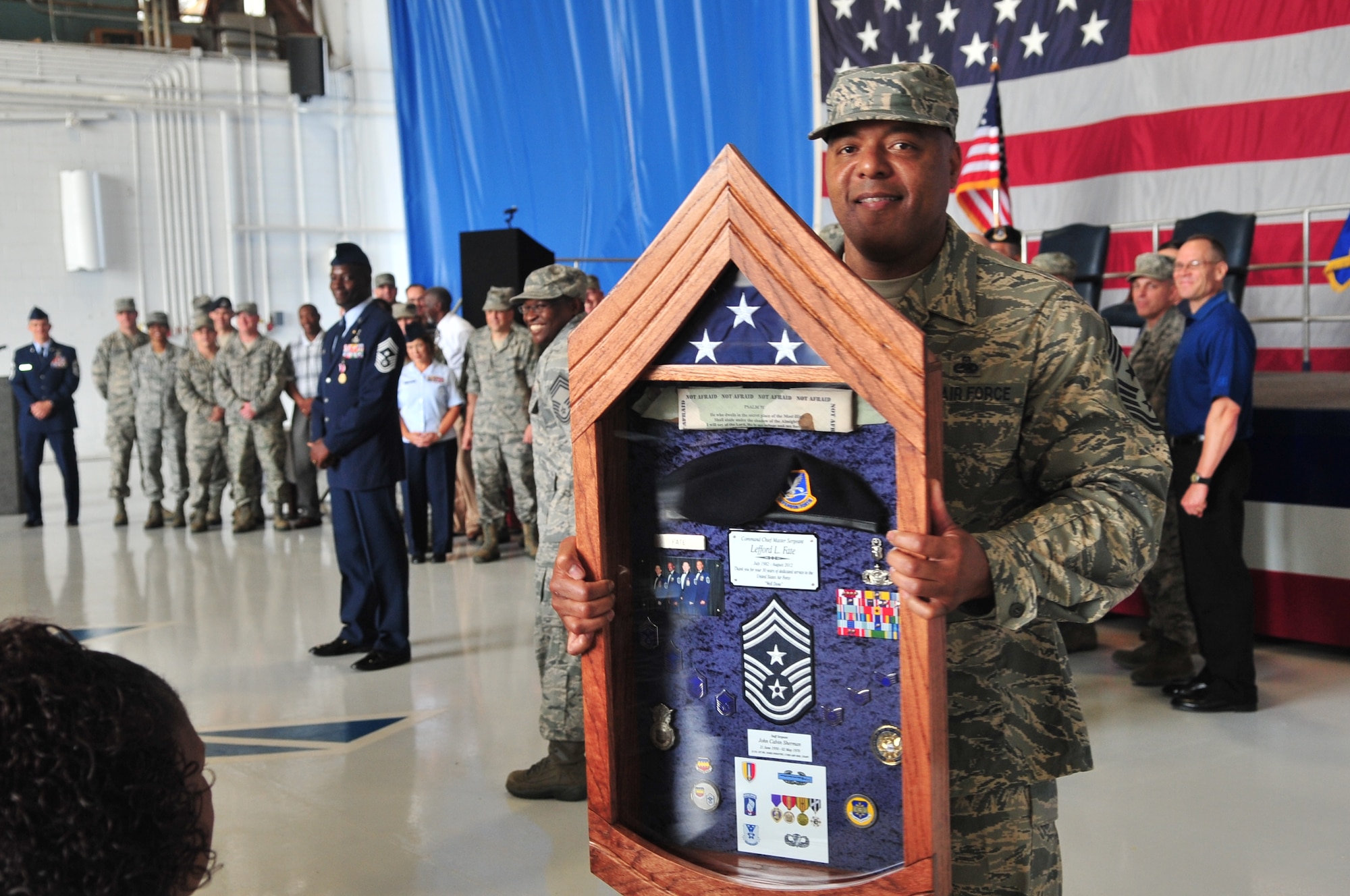 U.S. Air Force Chief Master Sgt. James Wilkerson shows Chief Master Sgt. Lefford Fate’s shadow box during Fate’s retirement ceremony, Shaw Air Force Base, S.C., May 1, 2012. Fate retired at Shaw after serving 30 in years in the Air Force. (U.S. Air Force photo by Airman 1st Class Ashley L. Gardner/ Released)