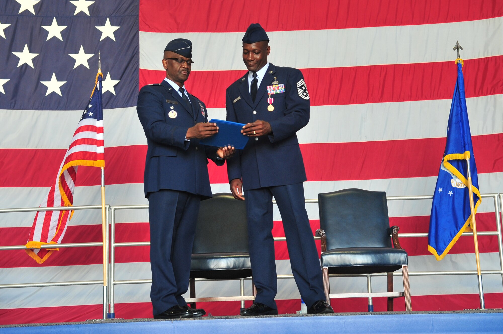 U.S. Air Force Col. Freddie J. Sherman, Department of State for Afghanistan transition, logistics directorate, and Chief Master Sgt. Lefford Fate, 20th Fighter Wing command chief, read a certificate during Fate’s retirement ceremony, Shaw Air Force Base, S.C. May 1, 2012. Fate was responsible for military standards, morale, welfare, training, professional development, and good order and discipline for more than 4,300 enlisted personnel assigned to Shaw. Fate retired after 30 years of service. (U.S. Air Force photo by Airman 1st Class Ashley L. Gardner/ Released)