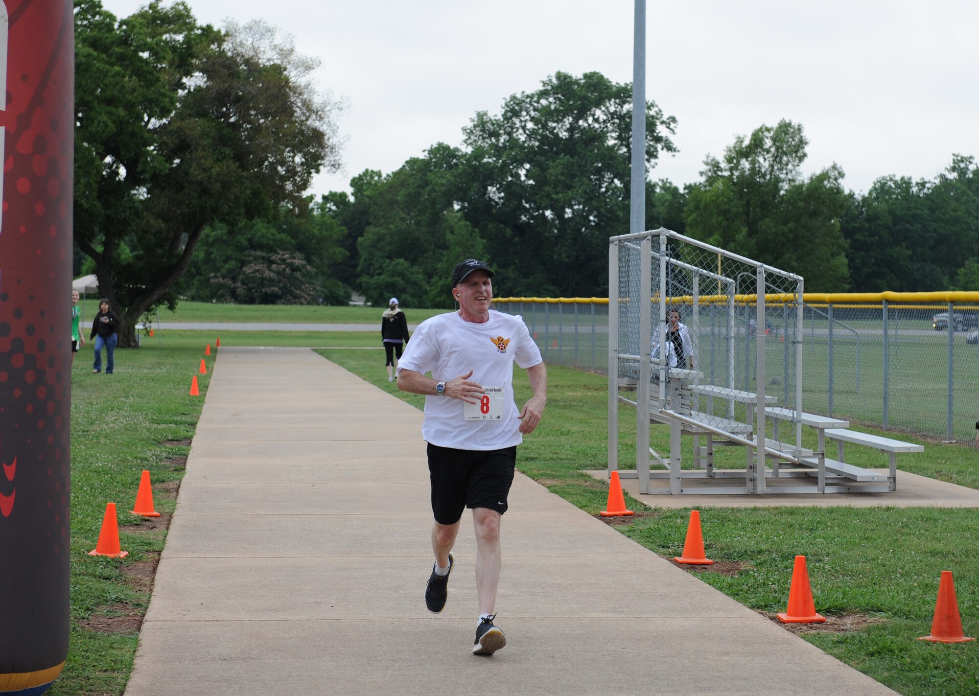 Maj. Gen. Stephen Wilson, Eighth Air Force commander, crosses the finish line during the inaugural Mighty Eighth 8 Miler on Barksdale Air Force Base, La., May 12. More than 110 base personnel and sponsored guests participated in the eight-mile run or a 5k event. (U.S. Air Force photo/Airman 1st Class Benjamin Gonsier)(RELEASED)
