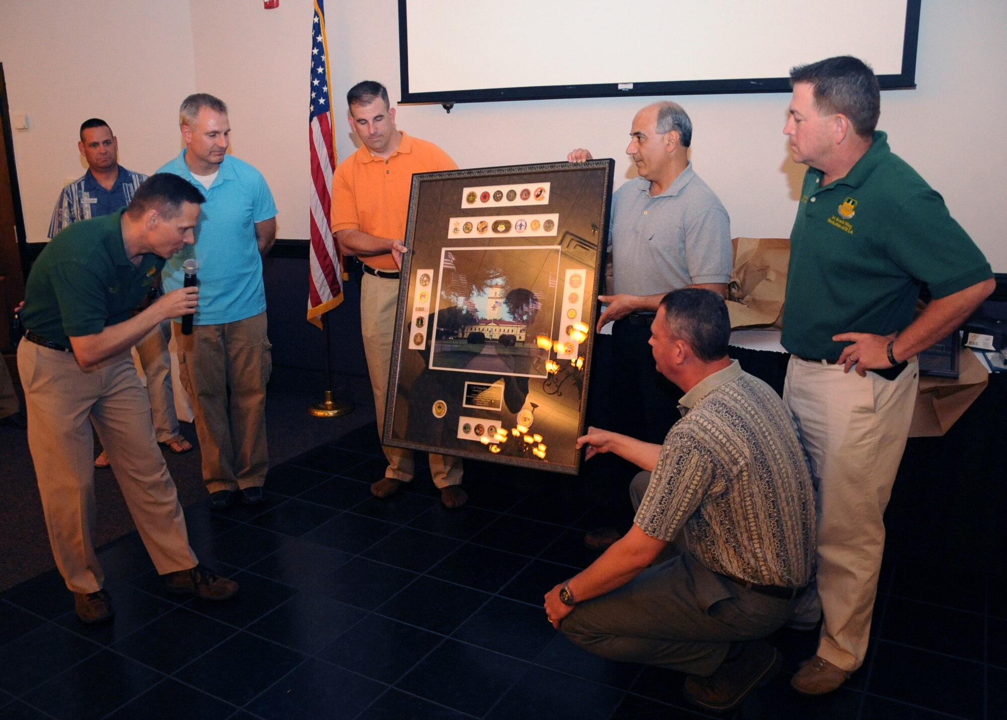 Col. Tom Hesterman, 2nd Bomb Wing vice commander, group and squadron commanders present Col. Tim Fay, 2 BW commander, with a gift during a farewell dinner on Barksdale Air Force Base, La., May 11. The picture contained coins from all the wing units as well an image of the wing headquarters. (U.S. Air Force photo/Senior Airman Sean Martin)(RELEASED)