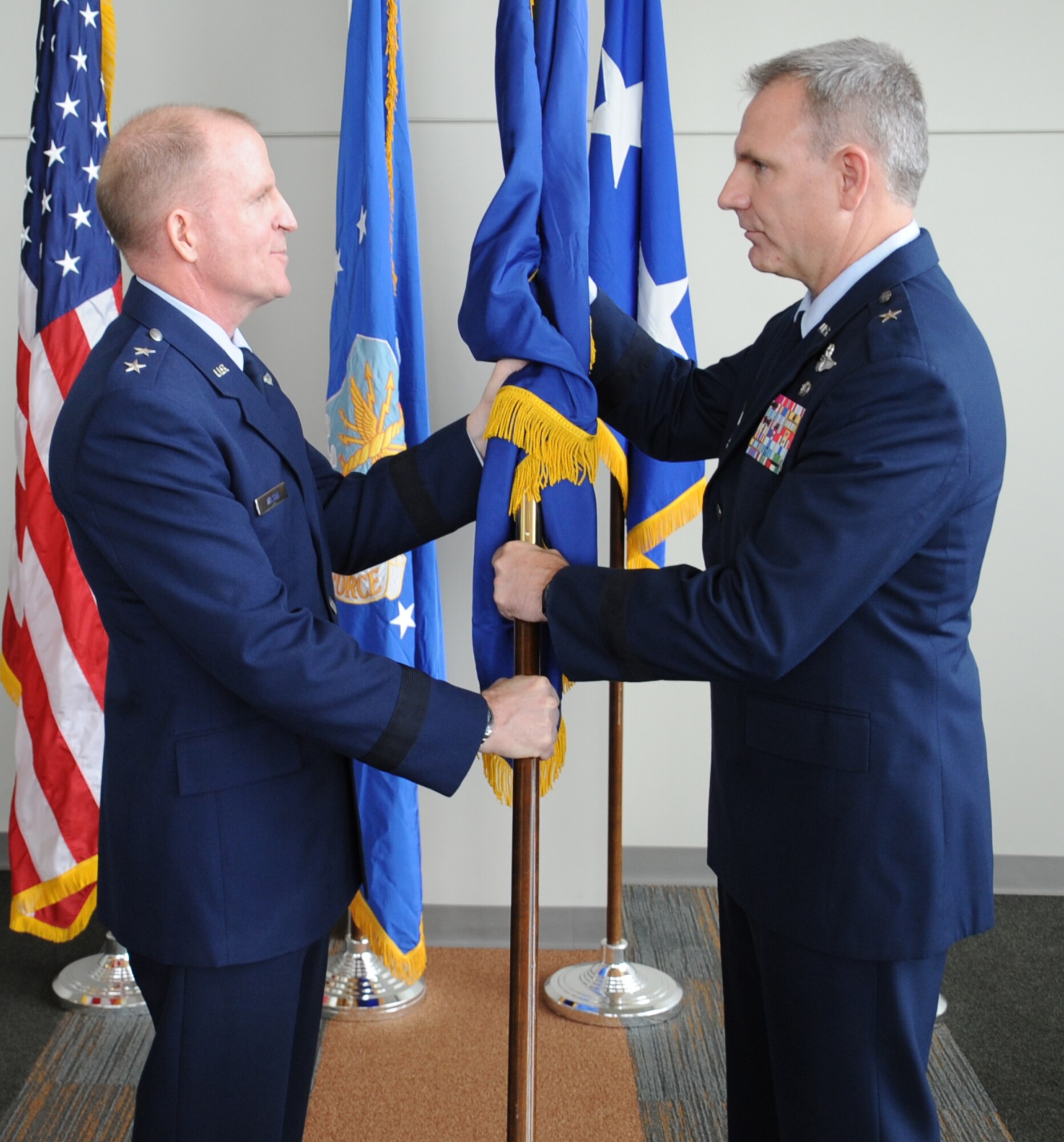 Maj. Gen. Stephen Wilson, 8th Air Force commander, presents Brig. Gen. Tim Fay, outgoing 2nd Bomb Wing commander, with  a brigadier general flag during his promotion ceremony at the Cyber Innovation Center in Bossier City, La., May 14. Fay's next assignment will be at the Pentagon after serving as the Barksdale Air Force Base commander for two years. (U.S. Air Force photo/Senior Airman Sean Martin)(RELEASED)
