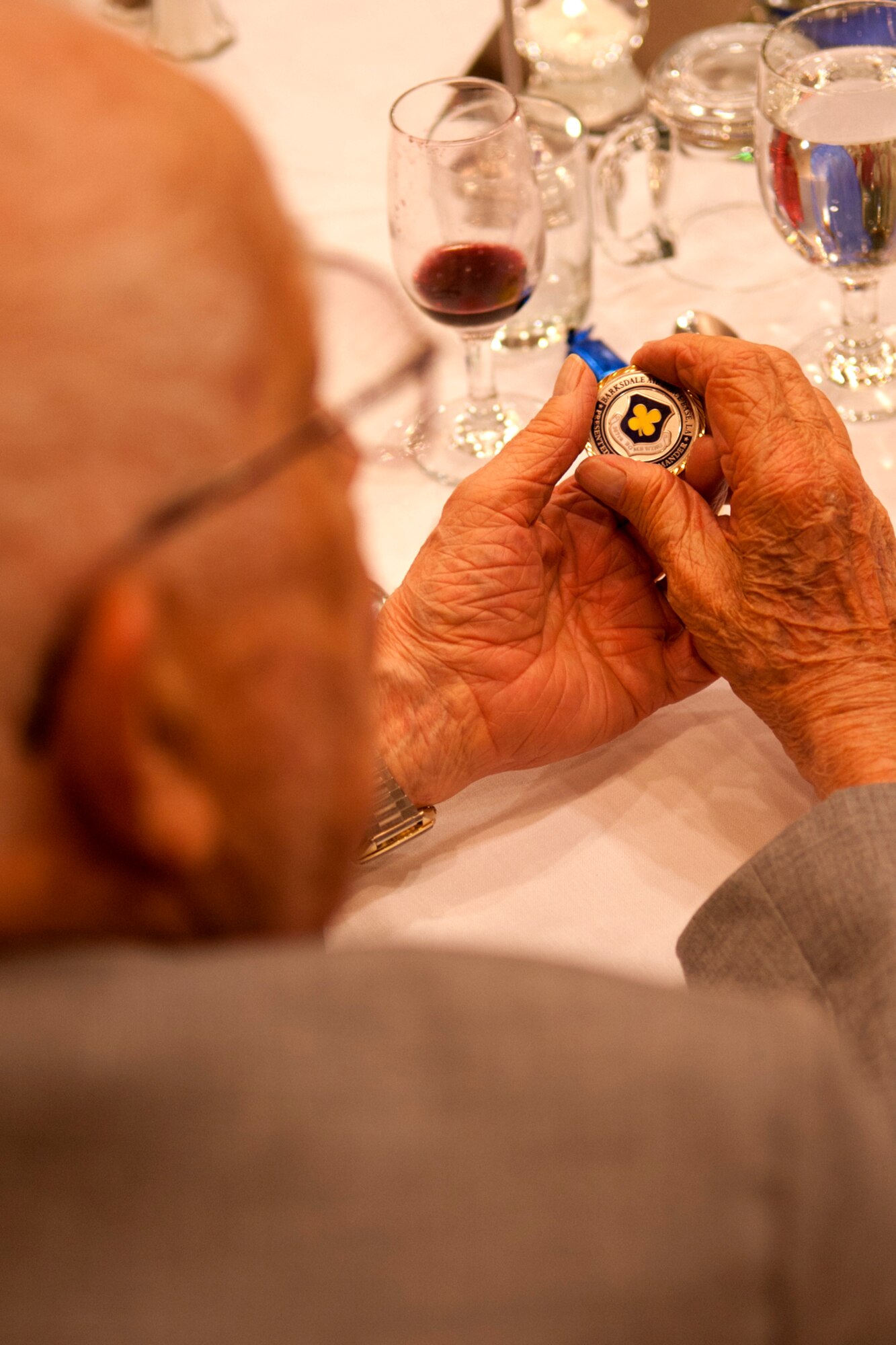 Tony Minnick admires a 307th Bomb Wing coin presented to him during the 307th Bomb Wing Association reunion banquet at Lincoln, Neb., May 5, 2012. Minnick is the treasurer for the association and was assigned to the bomb wing during its activation at Lincoln Air Force Base during the 1950s and 60s. (U.S. Air Force photo by Master Sgt. Greg Steele/Released)