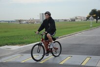 Airman 1st Class Cory Linder, 902nd Civil Engineer Squadron fire emergency services firefighter, crosses the final denial barrier at the East Gate cautiously on Joint Base San Antonio-Randolph May 14. JBSA-Randolph stresses bicycle safety everyday.  (U.S. Air Force photo/Rich McFadden) 