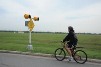 Airman 1st Class Cory Linder, 902nd Civil Engineer Squadron fire emergency services firefighter, approaches the final denial barrier at the East Gate on Joint Base San Antonio-Randolph May 14. JBSA-Randolph stresses bicycle safety everyday.  (U.S. Air Force photo/Rich McFadden) 