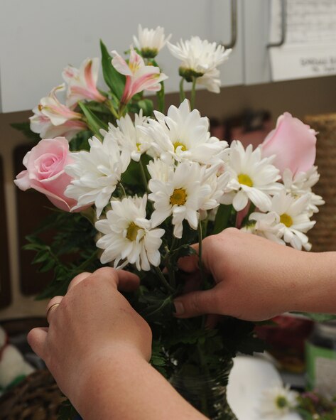 Brandy Daingerfield, Petals and Blooms floral designer, arranges flowers in a vase at the flower shop on Seymour Johnson Air Force Base, N.C., May 11, 2012. On an average day, the florists make more than 15 flower arrangements. Daingerfield, spouse of U.S. Air Force Tech. Sgt. Michael Daingerfield, 4th Communications Squadron NCO in-charge of infrastructure, hails from Woodbury, Tenn.  (U.S. Air Force photo/Airman 1st Class John Nieves Camacho/Released)
