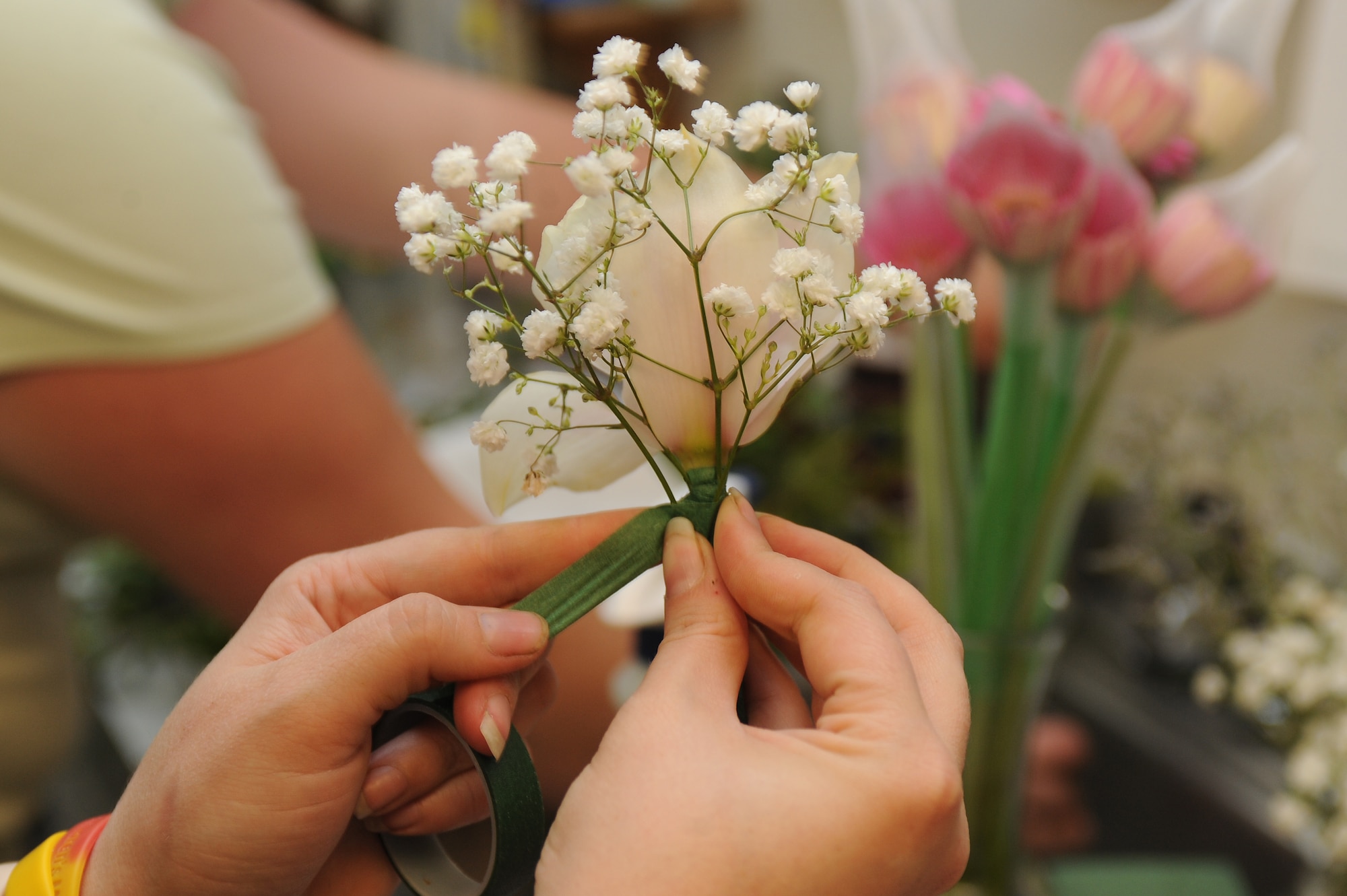 Adrienne Dawley wraps floral tape around an orchid and baby’s breath at the flower shop on Seymour Johnson Air Force Base, N.C., May 11, 2012. The floral tape holds elements of a design together which gives the bouquet a better appearance. Dawley, Petals and Blooms manager, is from Goldsboro, N.C. (U.S. Air Force photo/Airman 1st Class John Nieves Camacho/Released)