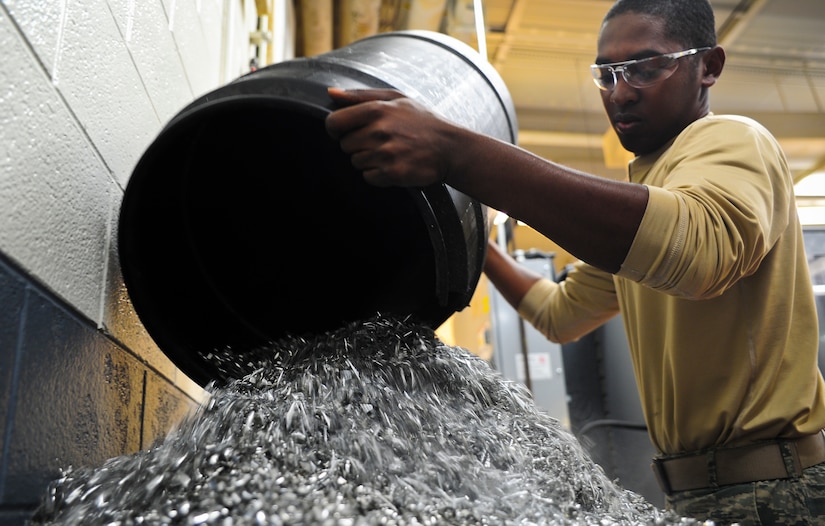 Airman 1st Class Tashma Antoine, an aircraft metals apprentice with the 437th Maintenance Squadron out of Joint Base Charleston, S.C., empties a trash can full of aluminum metal shavings he accumulated throughout the day into a recycling bin May 9, 2012. All shavings in the shop are gathered and paced in the bin to be recycled. Antoine is originally from Fort Myers, Fla. (U.S. Air Force photo/Airman 1st Class Dennis Sloan)