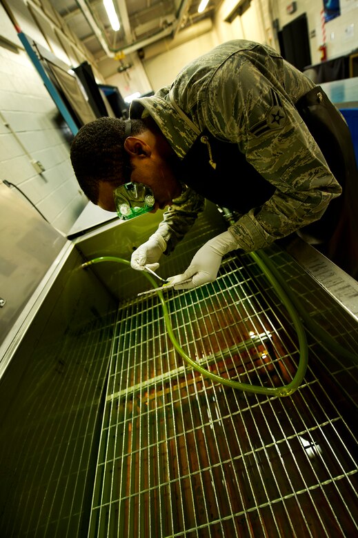 Airman 1st Class James Rogers, a non-destructive inspector with the 437th Maintenance Squadron out of Joint Base Charleston, S.C., demonstrates the use of the penetrate inspection line May 9, 2012. The inspection line uses chemicals and ultraviolet lights to detect cracks and flaws in metal. (U.S. Air Force photo/Airman 1st Class George Goslin)
