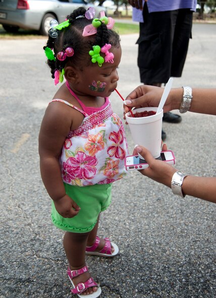 Kalia Davis, daughter of Tech. Sgt. Sierra and Staff Sgt. Darryl Davis, enjoys a snowcone during the 403rd Wing's Family Day May 5. (U.S. Air Force photo by Maj. Heather Newcomb)