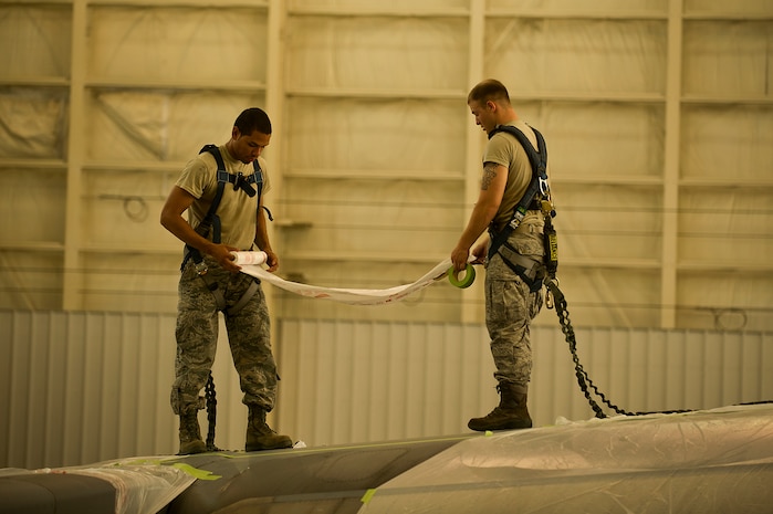 Senior Airman Ken Spruell and Airman 1st Class Justin Marcum, an aircraft metals technology craftsman with the 315th Maintenance Squadron out of Joint Base Charleston, S.C., mask parts of a C-17 Globemaster III before being painted May 9, 2012. The Airmen mask parts of the C-17 to prevent them from being painted with the rest of the plane. (U.S. Air Force photo/Airman 1st Class George Goslin)