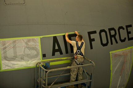 Air Force Reserve Staff Sgt. James Jordan, an aircraft metals technology craftsman with the 315th Maintenance Squadron out of Joint Base Charleston, S.C., masks letters spelling "'U.S. Air Force" on a C-17 Globemaster III before being painted May 9, 2012. The Airmen mask parts of the C-17 to prevent them from being painted with the rest of the plane. (U.S. Air Force photo/Airman 1st Class George Goslin)
