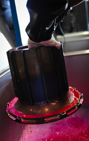 Airman 1st Class James Rogers, a non-destructive inspector with the 437th Maintenance Squadron out of Joint Base Charleston, S.C., lifts a torque tube out of a container after applying a special dye which after drying and placing under black lights will reveal crack and flaws in the metal May 9, 2012. After the tube is dried it is sprayed off with water and put through two more chemical baths, dried once more and then inspected under black lights. (U.S. Air Force photo/Airman 1st Class Dennis Sloan)