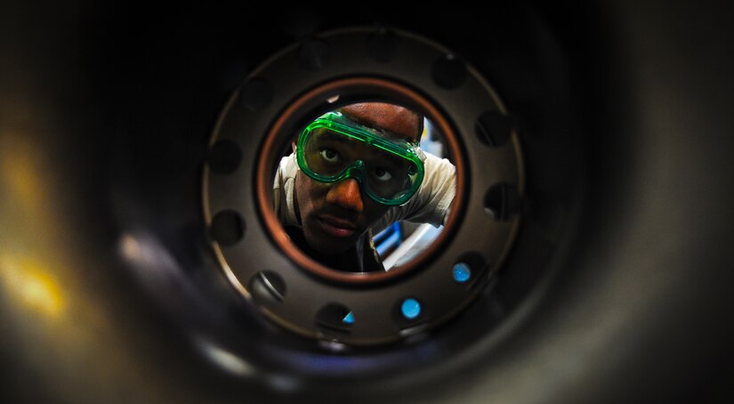 Airman 1st Class James Rogers, a non-destructive inspector with the 437th Maintenance Squadron out of Joint Base Charleston, S.C., looks inside a torque tube for water or residue before applying a special dye May 9, 2012. The inspection line uses chemicals and ultraviolet lights to detect cracks and flaws in metal. The inspection process can take up to an hour for each tube, running them through three separate chemical baths and a special drying machine. (U.S. Air Force photo/Airman 1st Class Dennis Sloan)