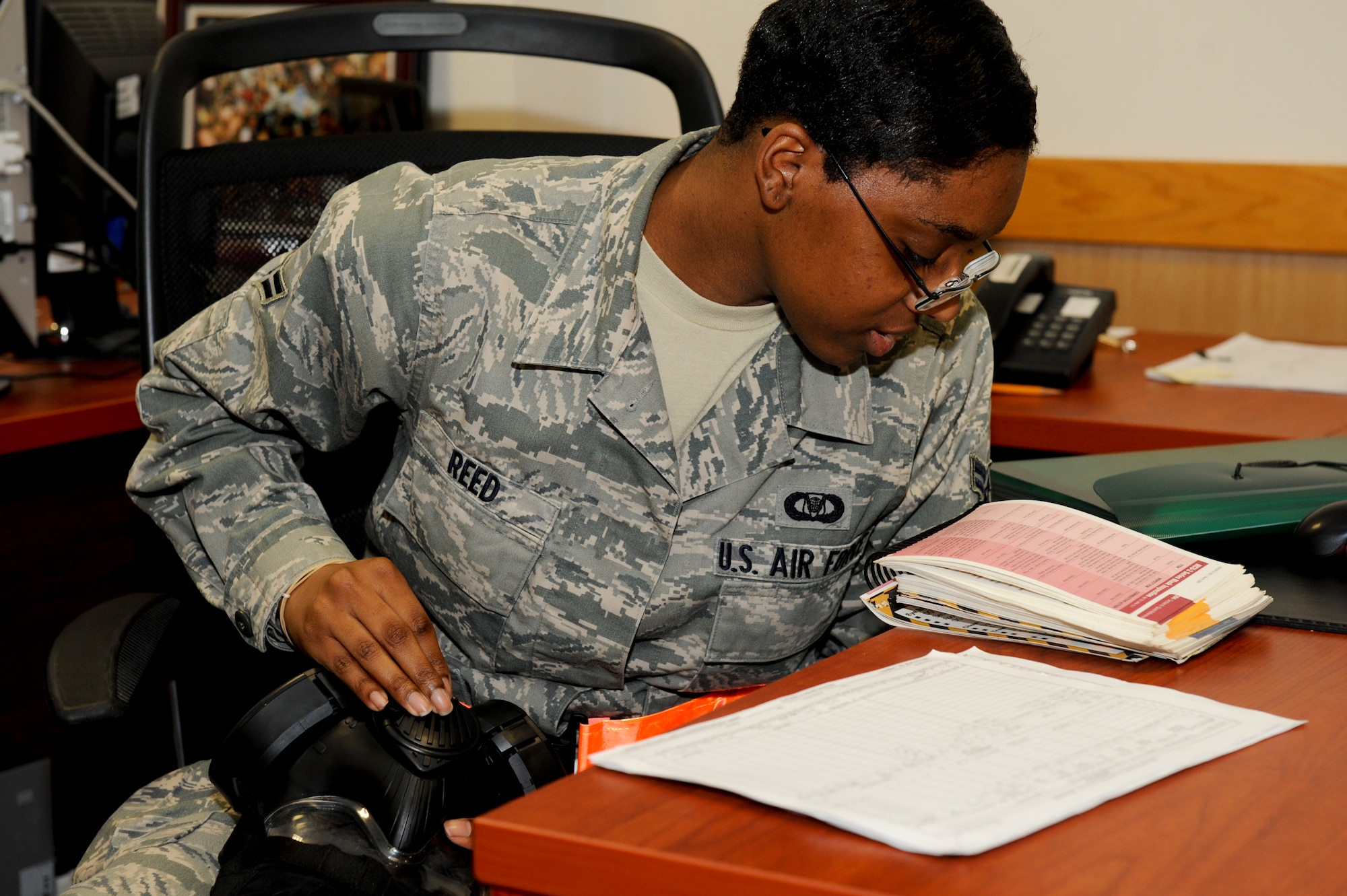 U.S. Air Force Airman 1st Rachel Reed, 909th Air Refueling Squadron, refers to her Airman's Manual while inspecting her gas mask during local operational readiness exercise Beverly High 12-4 on Kadena Air Base, Japan, May 14, 2012. Airmen are encouraged to use the Airman's Manual to find the proper procedures to help them through situations simulated during Beverly High 12-4. (U.S. Air Force photo/Airman 1st Class Hailey R. Davis)