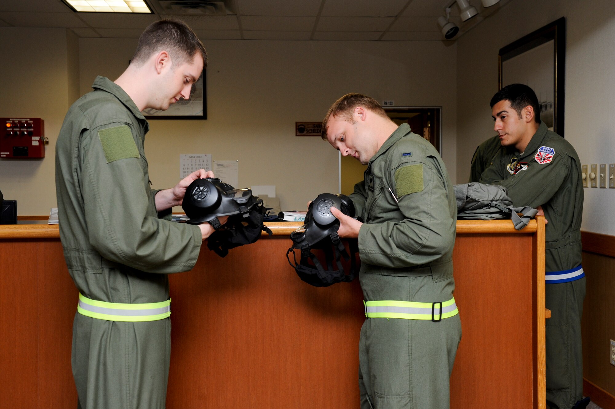 U.S. Air Force Airman 1st Class Derek Greene and U.S. Air Force 1st Lt. Jacob Lambach, 909th Air Refueling Squadron, inspect gas masks while Staff Sgt. Don Johnson (right) evaulates them during local operational readiness exercise Beverly High 12-4 on Kadena Air Base, Japan, May 14, 2012. LOREs give Airmen the opportunity to practice readiness skills and prepare for real-world contingencies. (U.S. Air Force photo by Airman 1st Class Hailey R. Davis/Released)