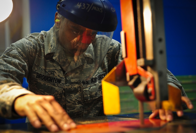 Senior Airman Tyrell Broughton, an aircraft metals technology journeyman with the 437th Maintenance Squadron out of Joint Base Charleston, S.C., cuts a sheet of metal with a bandsaw May 9, 2012. Aircraft metals specialists perform functions such as gas and electric welding, milling, machining, grinding metal, or using precision measuring devices. (U.S. Air Force photo/Airman 1st Class Dennis Sloan)