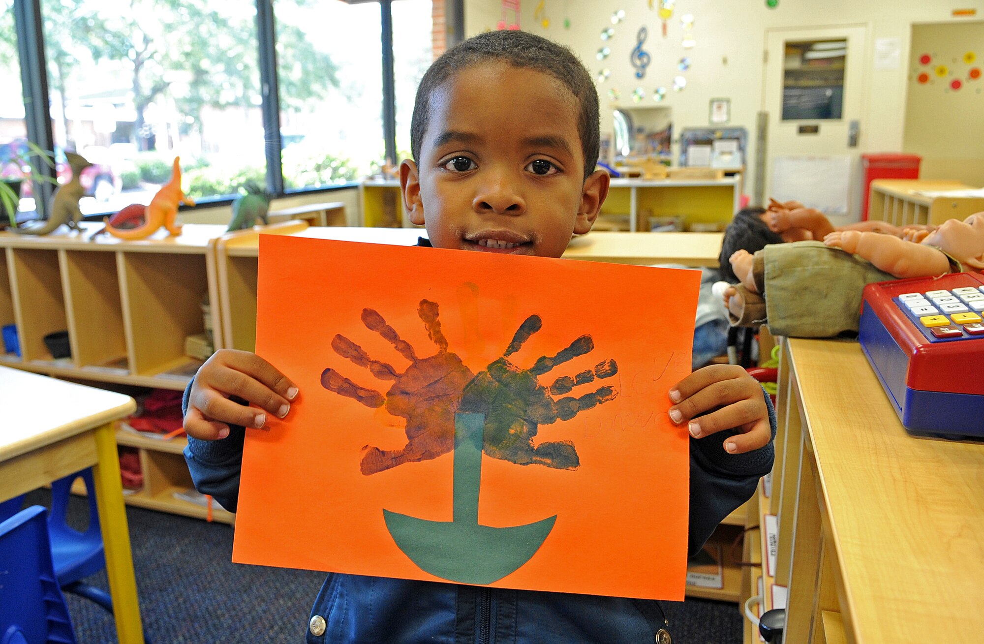 Donovan High, 4, holds a handprint flower he made as a Mother’s Day gift at the child development center on Seymour Johnson Air Force Base, N.C., May 11, 2012. Donovan celebrates his mother because she always cooks dinner for him. Donovan is the son of Staff Sgt. Lorena Davalos, 335th Aircraft Maintenance Unit. (U.S. Air Force photo/Airman 1st Class Aubrey Robinson/Released)