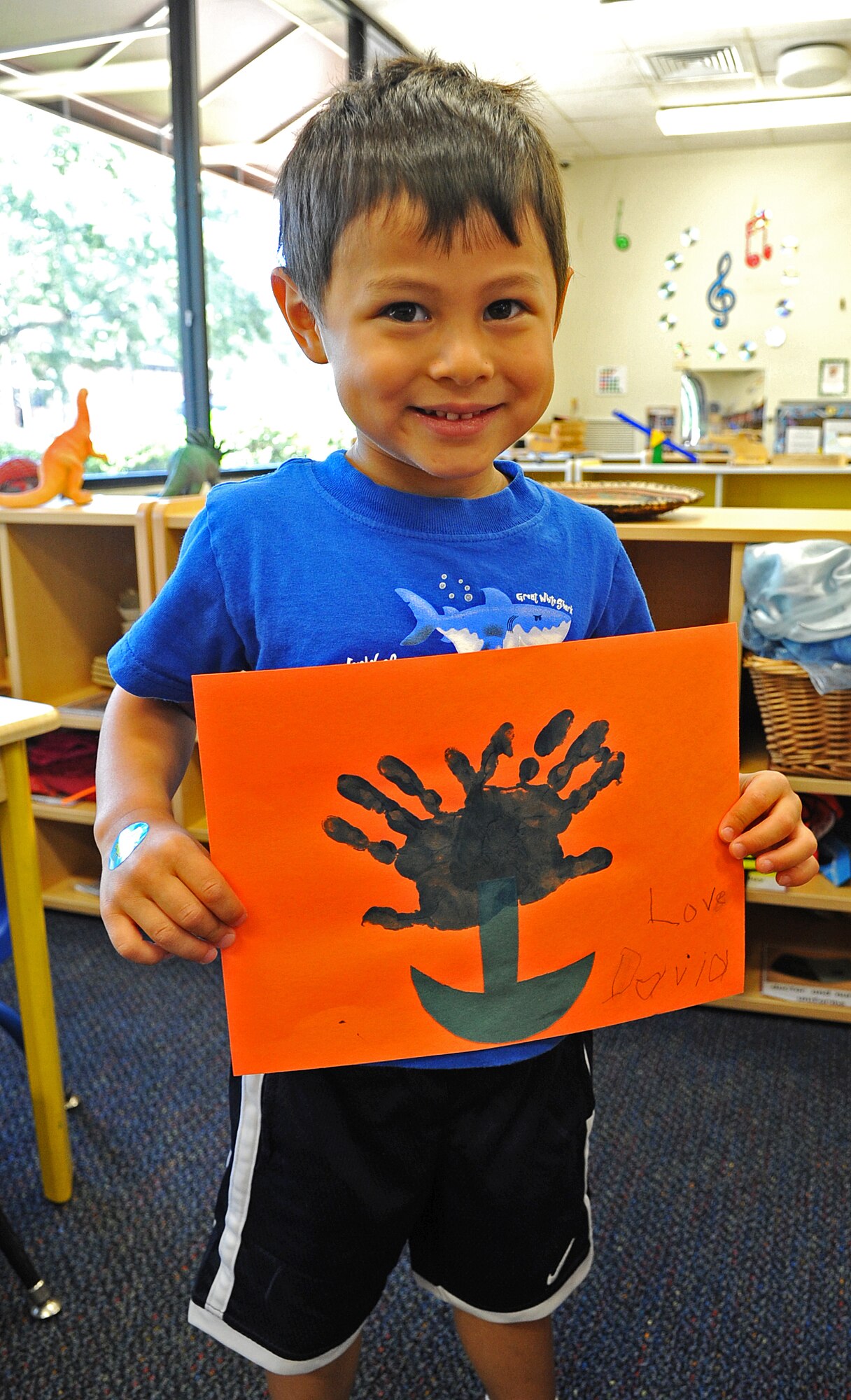 David Thode, 4, holds a blue handprint flower he made as a Mother’s Day gift at the child development center on Seymour Johnson Air Force Base, N.C., May 11, 2012. David painted the flower blue because it’s his mom’s favorite color. David is the son of Lt. Col. Alan Thode, 4th Operations Support Squadron, and Maj. Janette Thode, 4th Fighter Wing inspector general’s office. (U.S. Air Force photo/Airman 1st Class Aubrey Robinson/Released)