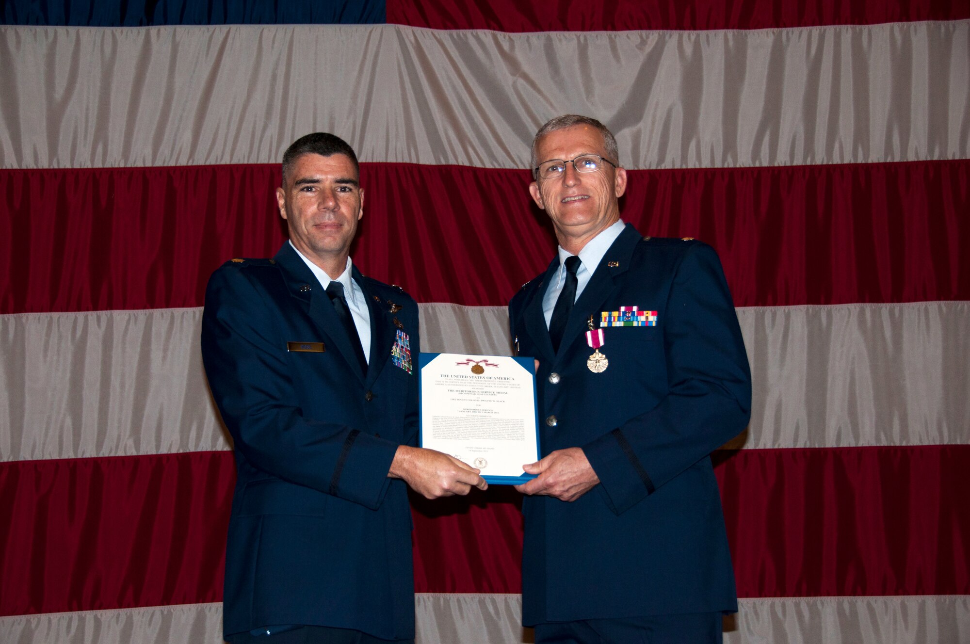 Lt. Col. Kenneth Rose, the 307th Maintenance Group commander, presents the Meritorious Service Medal to Lt. Col. Dwayne Slack, 707th Maintenance Squadron commander, at Barksdale Air Force Base, La., May 5, 2012.  Under Slack’s command, the 707 MXS helped the Air Force Reserve Command's only B-52 wing achieve a 79 percent mission capable rate, the highest average rate within the B-52 fleet.  Slack also led his team to first place honors for the Best Aircraft Maintenance Squadron and Best Crew Chief during Global Strike Command's inaugural BUFFSMOKE Competition.  The MSM presentation took place during commander’s call. (U.S. Air Force photo by Staff Sgt. Ted Daigle/Released). 
