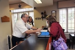 Marty Spencer (left) and Sherita Scott (center), 902nd Force Support Squadron innkeepers, provide lodging support to Holly Antle during her relocation to Joint Base San Antonio-Randolph May 14. JBSA-Randolph Lodging recently won the Air Education and Training Command Innkeeper Award and will now compete at Air Force level. (U.S. Air Force photo/Rich McFadden) 