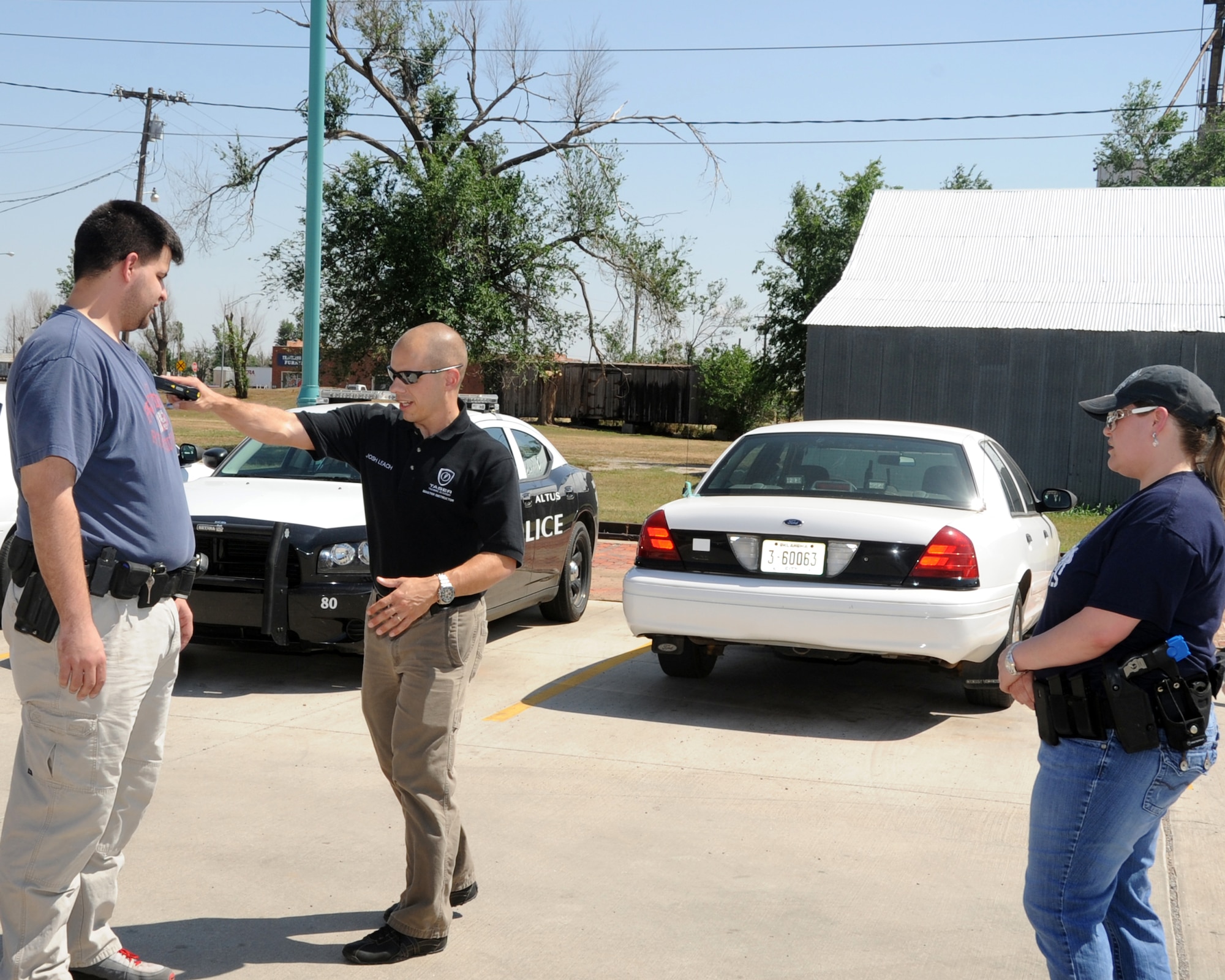 ALTUS, Okla. -- Joshua Leach, 97th Security Forces Squadron lead investigator and master Taser instructor, demonstrates how to use a Taser at close distances with members of the City of Altus Police Department during a Taser training May 1, 2012 at the Altus Police Department. Leach is a certified master Taser instructor and recently re-certified 27 Altus police officers, which saved the city approximately $10,000. (U.S. Air Force photo by Airman 1st Class Kenneth W. Norman / Released / 97th Air Mobility Wing Public Affairs)