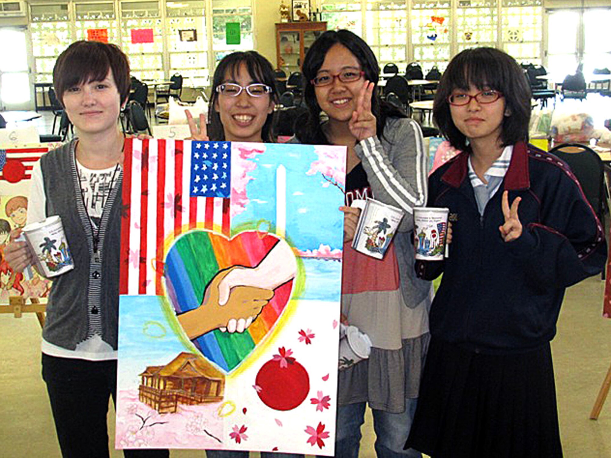 (Left to right) Kadena High School sophomore Amanda Anderson, Kana Tamamoto from Ginowan High School, Kie Oshiro from Shuri Higashi High School, and Chibana Yuria from Yomitan High School pose with their team's poster that won first place in a "Manga," or Japanese-style comics, contest sponsored by the American Consulate General Naha May 12. Students from Kadena and Kubasaki high schools and eight Okinawan schools participated in the contest that promoted friendship between American and Okinawan teens. (Courtesy photo by Aya Haemori.)