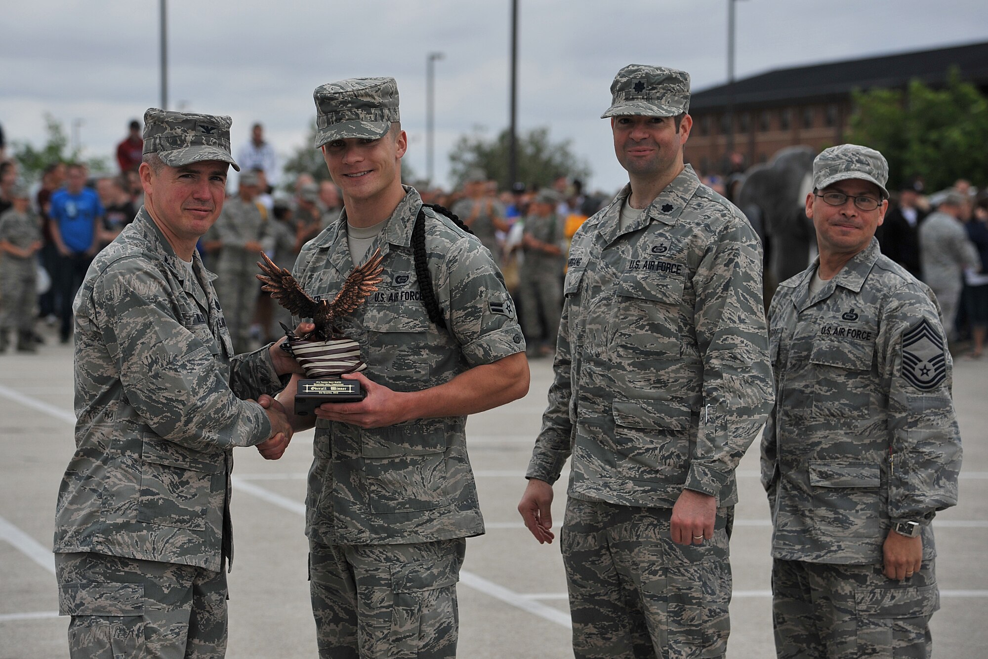 GOODFELLOW AIR FORCE BASE, Texas--Col. JD Willis, 17th Training Group Commander, and Chief Master Sgt. Raymond Irizarry, 17th TRG superintendent, present Airman 1st Class Charles Waller, 316th Training Squadron student, and Lt. Col. Scott Nahrgang, 316th TRS Commander, with the overall winner trophy of the drill competition May 12. The 316th TRS also won the open ranks and regulation drill portions of the competition. (U.S. Air Force photo/Airman 1st Class Michael Smith)