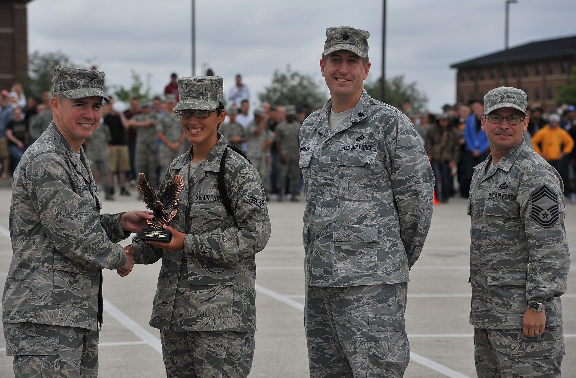 GOODFELLOW AIR FORCE BASE, Texas--Col. JD Willis, 17th Training Group Commander, and Chief Master Sgt. Raymond Irizarry, 17th TRG superintendent, present Airman 1st Class Kayla Garcia, 315th Training Squadron student, and Lt. Col. Christopher Huisman, 315th TRS Commander, with an award for winning the exhibition drill portion of the competition May 12. (U.S. Air Force photo/Airman 1st Class Michael Smith)