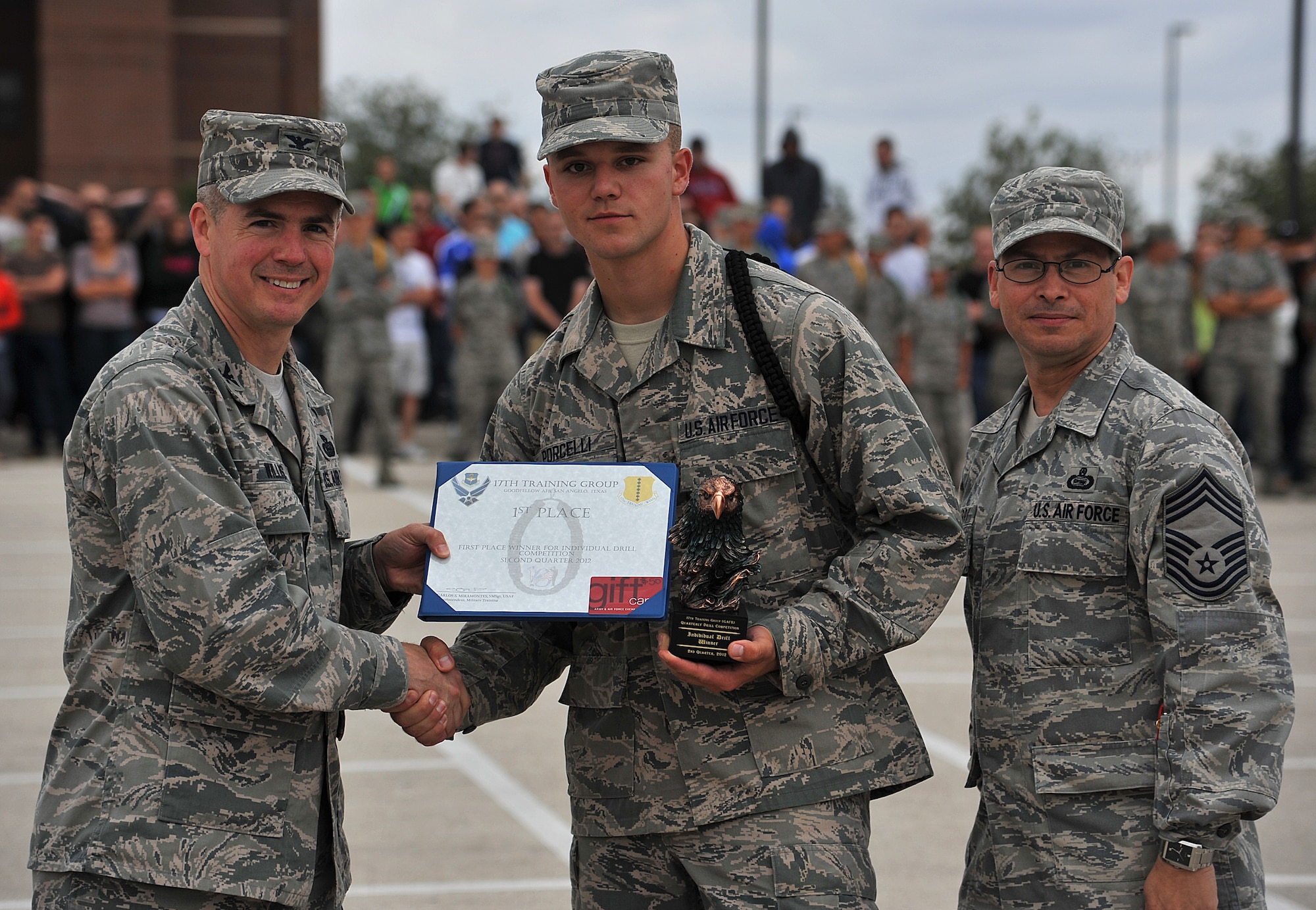 GOODFELLOW AIR FORCE BASE, Texas--Col. JD Willis, 17th Training Group Commander, and Chief Master Sgt. Raymond Irizarry, 17th TRG superintendent, present Airman 1st Class Jesse Porcelli, 312th Training Squadron student, with the first place award for individual drill at the drill competition May 12. (U.S. Air Force photo/Airman 1st Class Michael Smith)