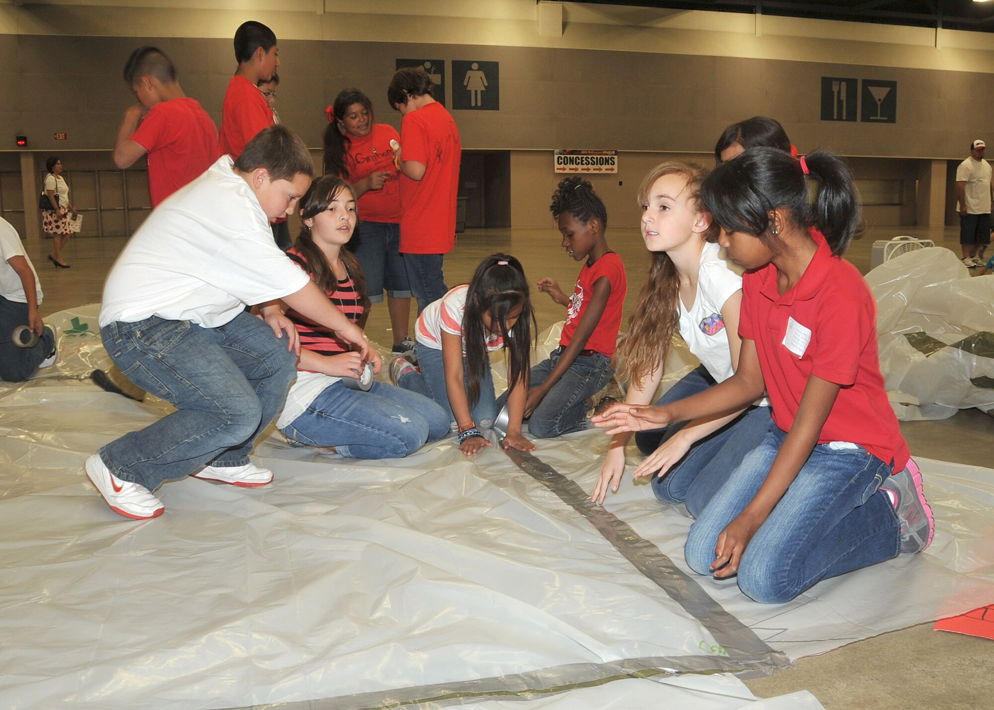 KIRTLAND AFB, N.M. -- Elementary school students from New Mexico tape down their Marsville Program Pod during the annual event May 4 at the Albuquerque Convention Center. (Photo by Todd Berenger)