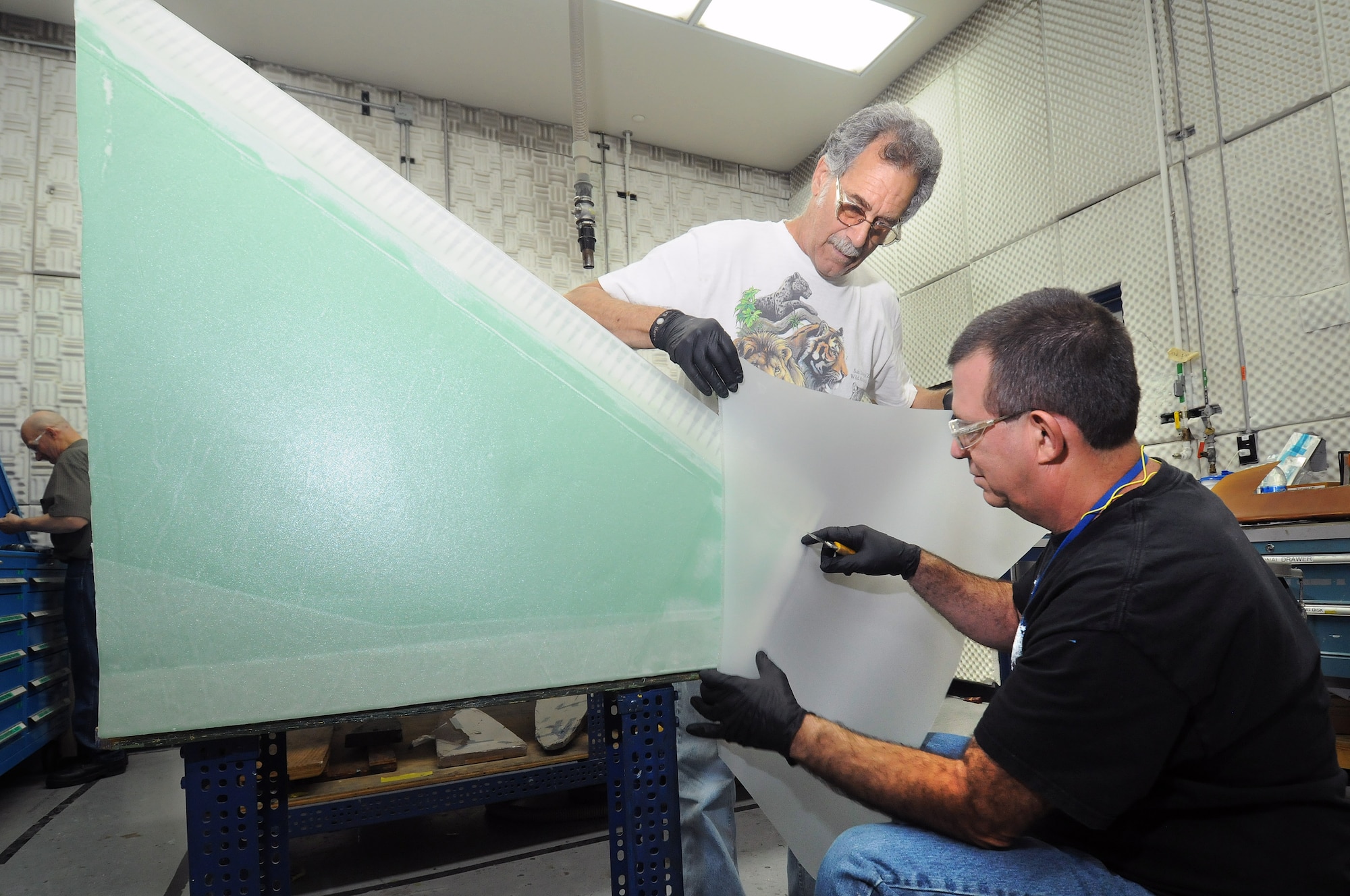 Installing a fiberglass skin on the inboard leading edge of a B1 horizontal stabilizer, in the Advanced Composites Shop in Bldg. 2211, are 551st CMMXS technicians Tom Appicello and Carl Hayward. (Air Force photo by Dave Faytinger)
