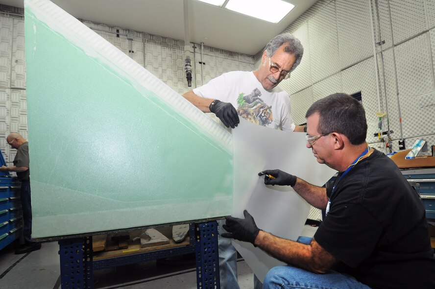 Installing a fiberglass skin on the inboard leading edge of a B1 horizontal stabilizer, in the Advanced Composites Shop in Bldg. 2211, are 551st CMMXS technicians Tom Appicello and Carl Hayward. (Air Force photo by Dave Faytinger)