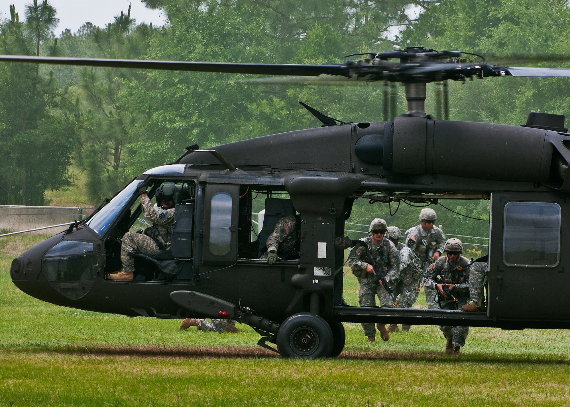 Rangers make their way to the UH-60 Blackhawk to exit the area during a scenario at the 6th Ranger Training Battalion’s annual open house event, May 12 at Eglin Air Force Base, Fla.  The event was a chance for the public to learn how Rangers train and operate. The event displays showed dive equipment, weapons, a reptile zoo and zodiac boats among others. The demonstrations showed off hand-to-hand combat, a parachute jump, a down-pilot scenario and others.  (U.S. Air Force photo/Samuel King Jr.)