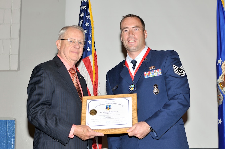 McGHEE TYSON AIR NATIONAL GUARD BASE, Tenn. - Tech. Sgt. James W. Swanson, right, receives the distinguished graduate award for NCO Academy Class 12-3 at the I.G. Training and Education Center from retired Chief Master Sgt. "Doc" McCauslin, Air Force Sergeants Association, April 12, 2012. The distinguished graduate award is presented to students in the top ten percent of the class.  It is based on objective and performance evaluations, demonstrated leadership, and performance as a team player. (Air National Guard photo by Master Sgt. Kurt Skoglund/Released) 