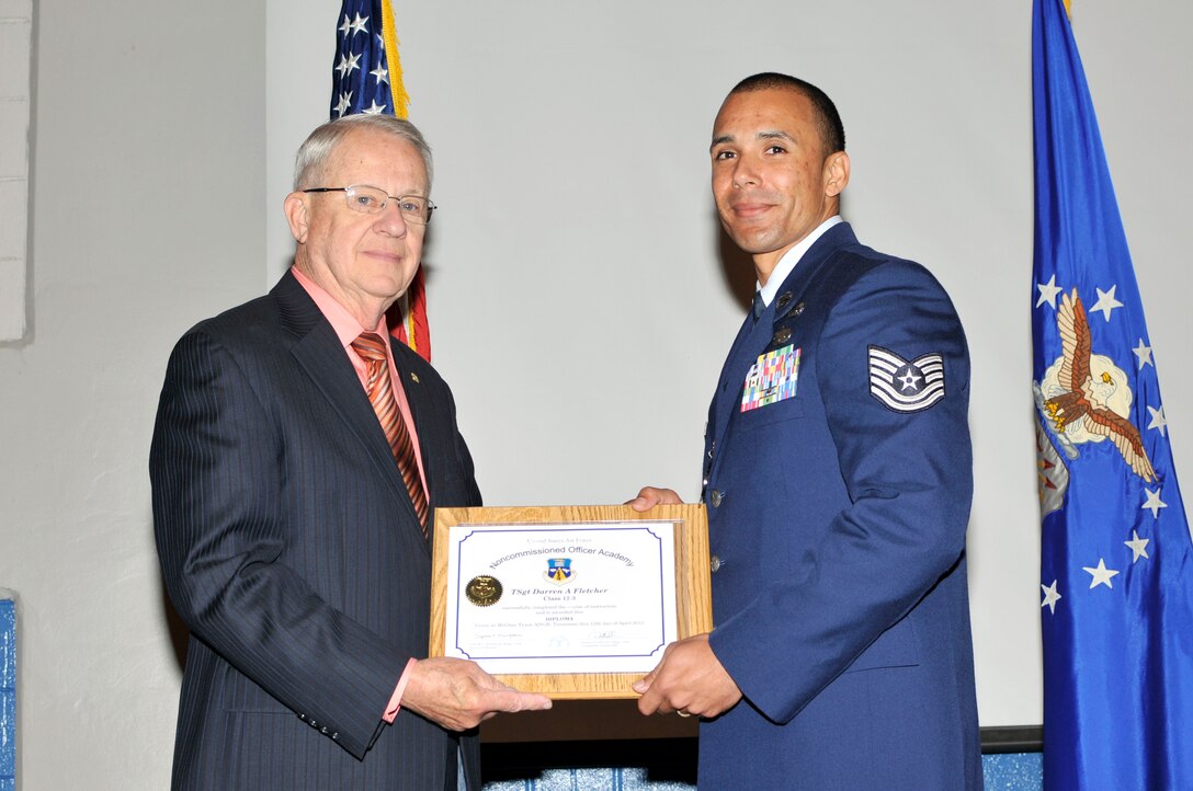 McGHEE TYSON AIR NATIONAL GUARD BASE, Tenn. - Tech. Sgt. Darren Fletcher, right, receives the distinguished graduate award for NCO Academy Class 12-3 at the I.G. Training and Education Center from retired Chief Master Sgt. "Doc" McCauslin, Air Force Sergeants Association, April 12, 2012. The distinguished graduate award is presented to students in the top ten percent of the class.  It is based on objective and performance evaluations, demonstrated leadership, and performance as a team player. (Air National Guard photo by Master Sgt. Kurt Skoglund/Released) 