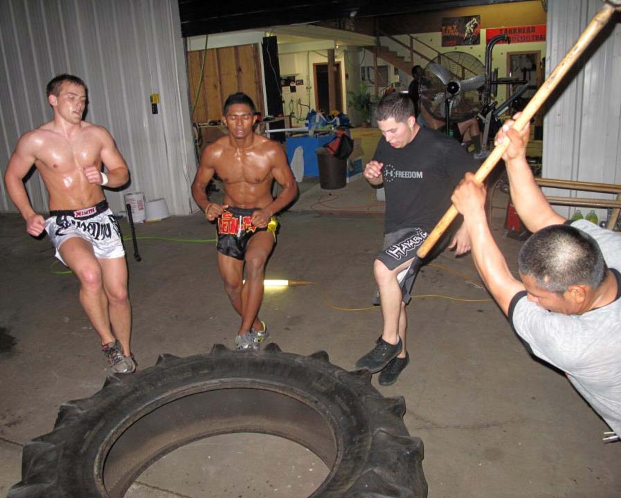 Airmen and Tankhead Fight Club members train using a large tire at Tankhead Fight Club in Shreveport, La., April 11. Mixed martial arts can help Airmen improve their physical training scores by improving strength, flexibility and resiliency. (Courtesy Photo)