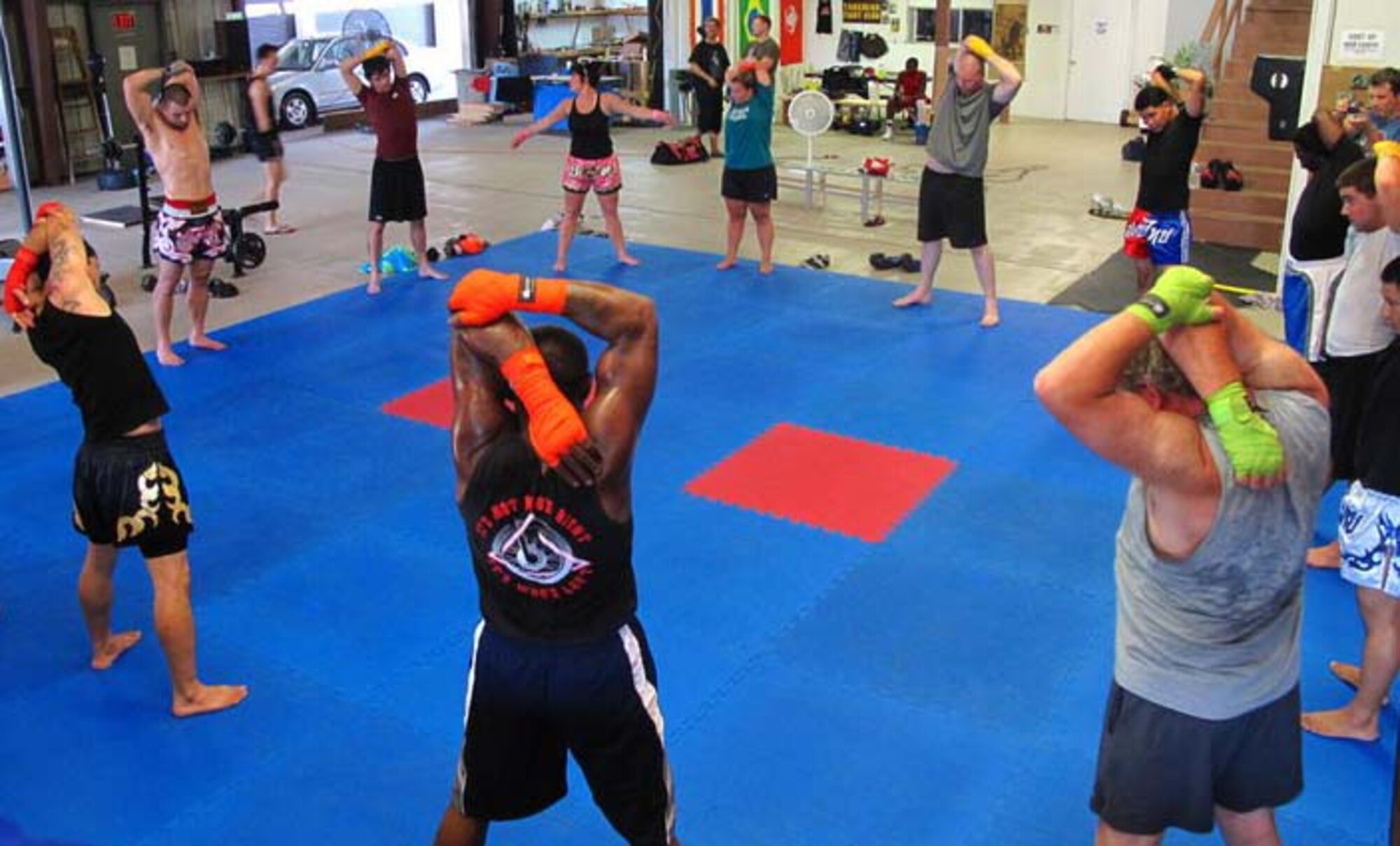 Airmen and Tankhead Fight Club members stretch before their workout at Tankhead Fight Club in Shreveport, La., April 11. Members are required to do light stretches before starting any mixed martial arts and Muay Thai training to assist in preventing injuries. (Courtesy Photo)