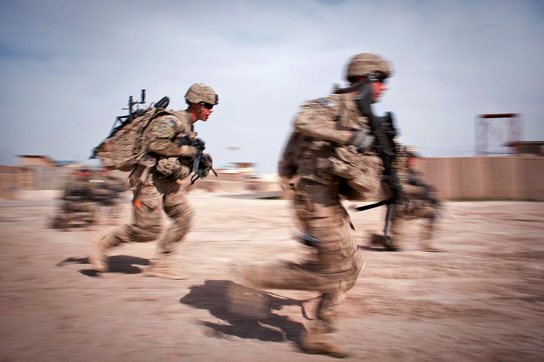 U.S. Army paratroopers sprint to emplace an M240-B machine gun as they demonstrate crew drills to Afghan soldiers before a foot patrol in Afghanistan's Ghazni province, May 8, 2012.