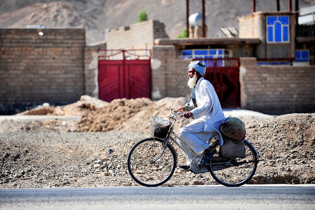 An Afghan man rides his bike along a street in Farah City in Afghanistan's Farah province, May 12, 2012.