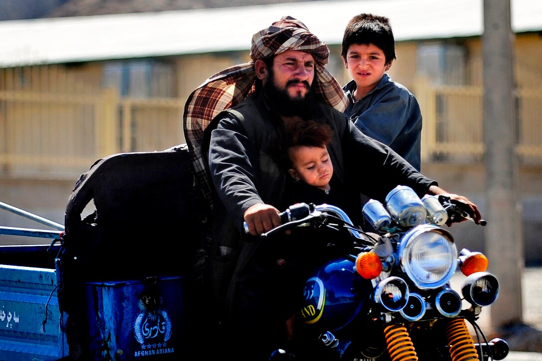 An Afghan man and his two sons take a ride on a motorcycle in Farah City in  Afghanistan's Farah province, May 12, 2012. 