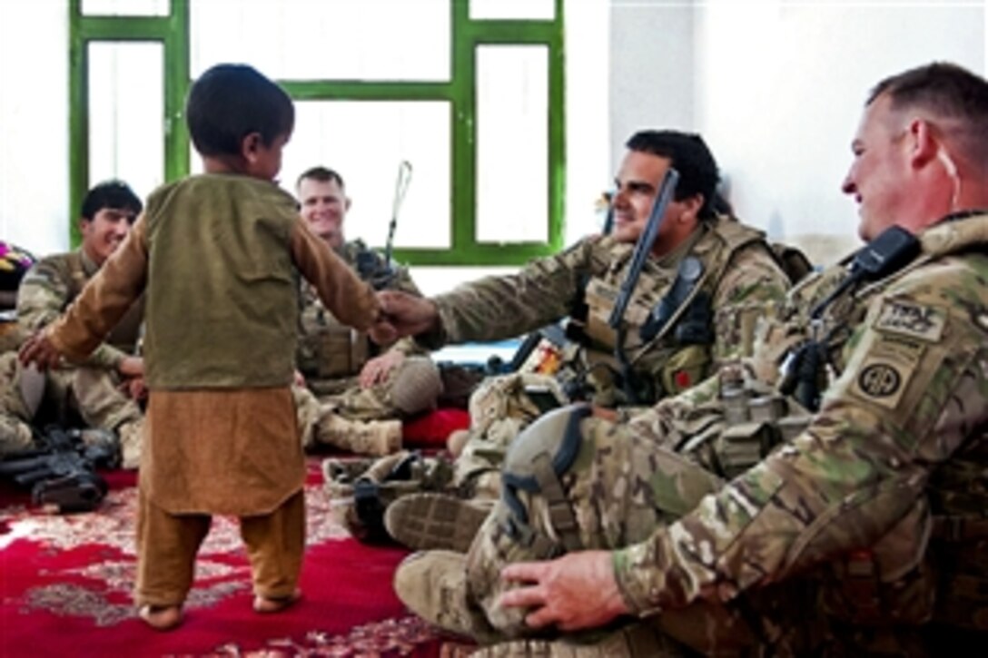 U.S. Army Spc. Timothy Rodgers shakes the hand of an Afghan boy during a meeting with the boy’s father, a village elder, in Afghanistan's Ghazni province, May 4, 2012. Dean, a infantryman, is assigned to the 82nd Airborne Division’s Company C, 2nd Battalion, 504th Parachute Infantry Regiment, 1st Brigade Combat Team.