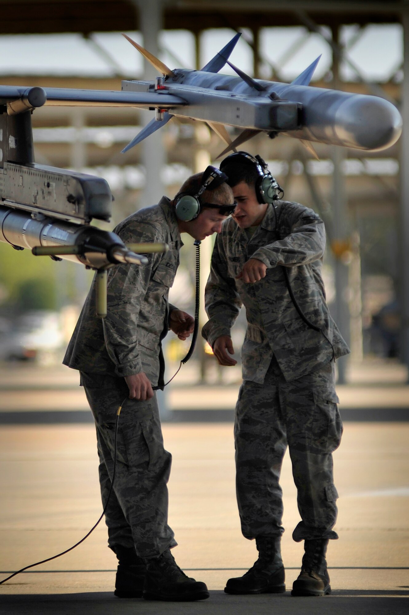 U.S. Air Force Senior Airman Jake Palmiero and Senior Airman Kelvin DeCato, 20th Aircraft Maintenance Squadron crew chiefs, talk with each other while performing last minute preflight checks on an F-16 Fighting Falcon before launching it, April 13, 2012, Shaw Air Force Base, S.C. Shaw's F-16 Fighting Falcon fleet is the number one asset that aids pilots when providing combat-ready airpower anytime, anywhere. (U.S. Air Force photo by Senior Airman Kenny Holston/Released)


