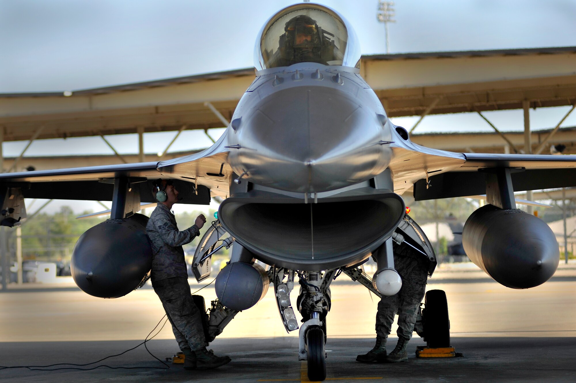 U.S. Air Force crew chiefs assigned to the 20th Aircraft Maintenance Squadron perform last minute checks on an F-16 Fighting Falcon before launching it, April 13, 2012, Shaw Air Force Base, S.C. Shaw's F-16 Fighting Falcon fleet is the number one asset that aids pilots when providing combat-ready airpower anytime, anywhere. (U.S. Air Force photo by Senior Airman Kenny Holston/Released)


