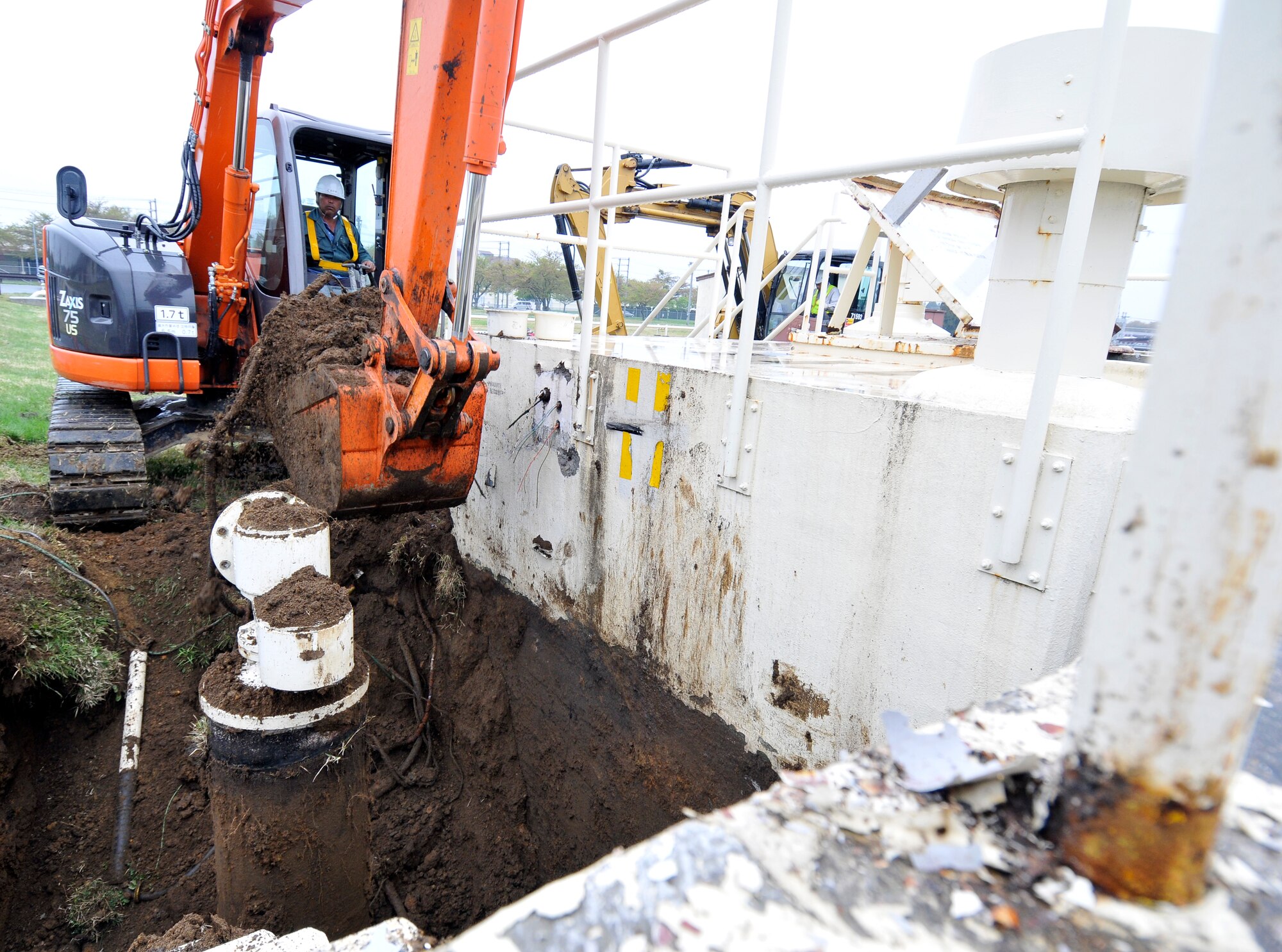 Hiroki Kobanoki, Japanese contractor, lifts dirt and other debris from around a power-fuel spigot at Misawa Air Base, Japan May 15, 2012. This project is budgeted at approximately $3.27 million and is scheduled to be finished in September. (U.S. Air Force photo by Tech. Sgt. Phillip Butterfield/Released)