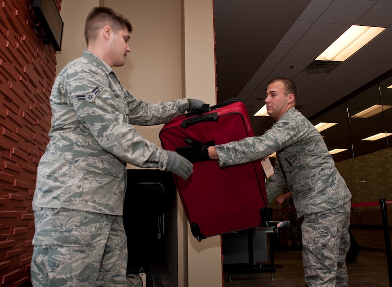 Airman 1st Class Stefen Ivanovic (left) and Senior Airman Jim Busby, 28th Aircraft Maintenance Squadron weapons load crew members, handle luggage after it has been scanned by transportation safety administration in preparation to leave for Green Flag, a combat training exercise at Nellis Air Force Base, Nev., in the deployment center at Ellsworth AFB, S.D., May 10, 2012. Ellsworth’s new deployment center will feature conveyer belts that will transport luggage from the TSA area to the aircraft for loading. (U.S. Air Force photo by Airman 1st Class Kate Thornton/Released)