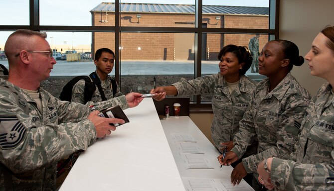 Airmen assigned to the 28th Bomb Wing verify their identity at the check-in counter as they prepare to leave for Green Flag, a combat training exercise at Nellis Air Force Base, Nev., in the deployment center at Ellsworth AFB, S.D., May 10, 2012. These Airmen were the first to process through Ellsworth’s new deployment center, proving its advanced organization and streamlined processes. (U.S. Air Force photo by Airman 1st Class Kate Thornton/Released)