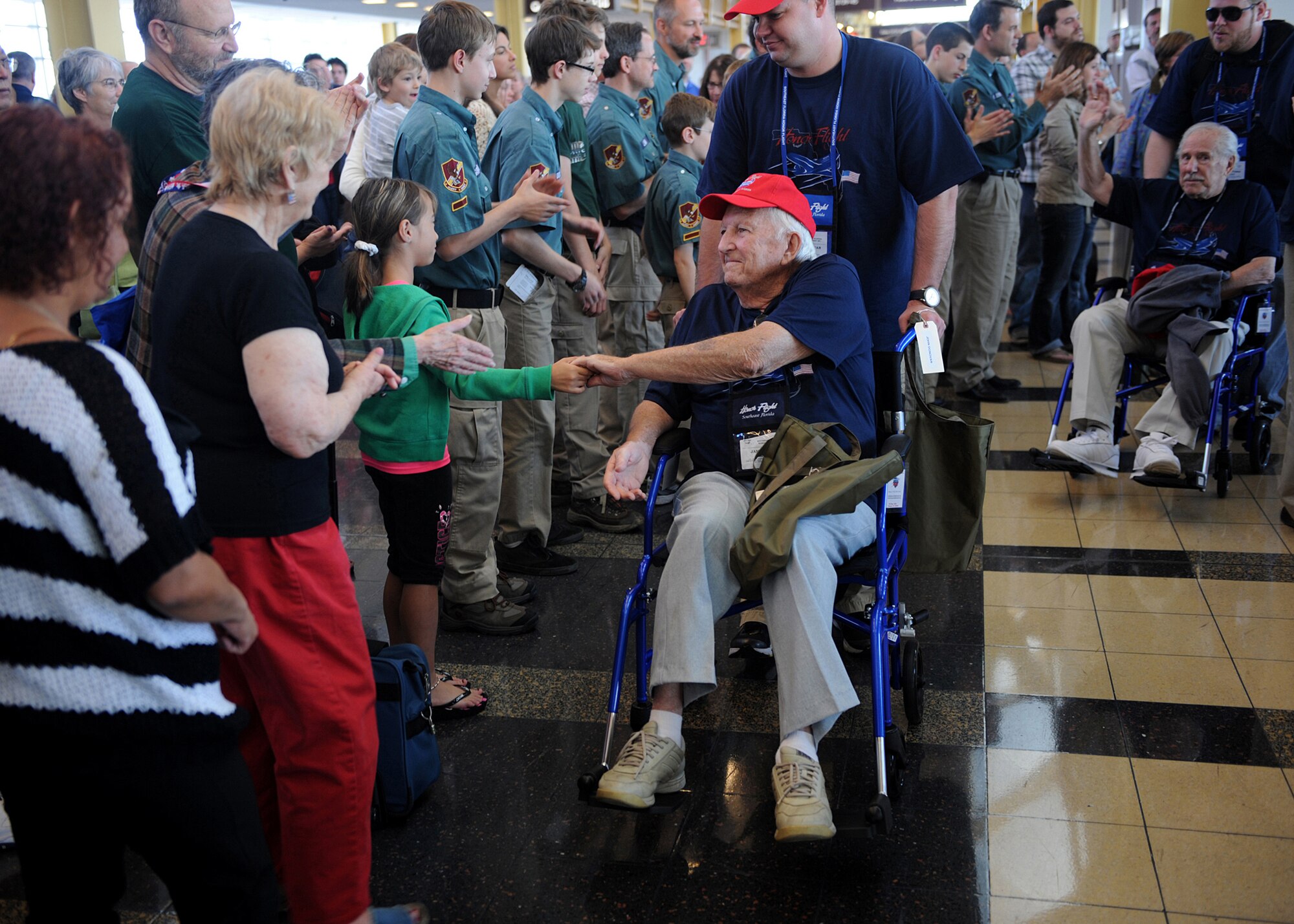 James Blair, a World War II veteran, shakes hands with the crowd as he arrives at Ronald Reagan National Airport on an Honor Flight May 12, 2012. The veterans are in the nation’s capital on an Honor Flight trip to visit the memorials that are dedicated to those who fought for our freedom. The Honor Flight Network is a nonprofit organization created solely to honor America’s veterans for all their sacrifices. (Air Force photo by Christina Brownlow)
