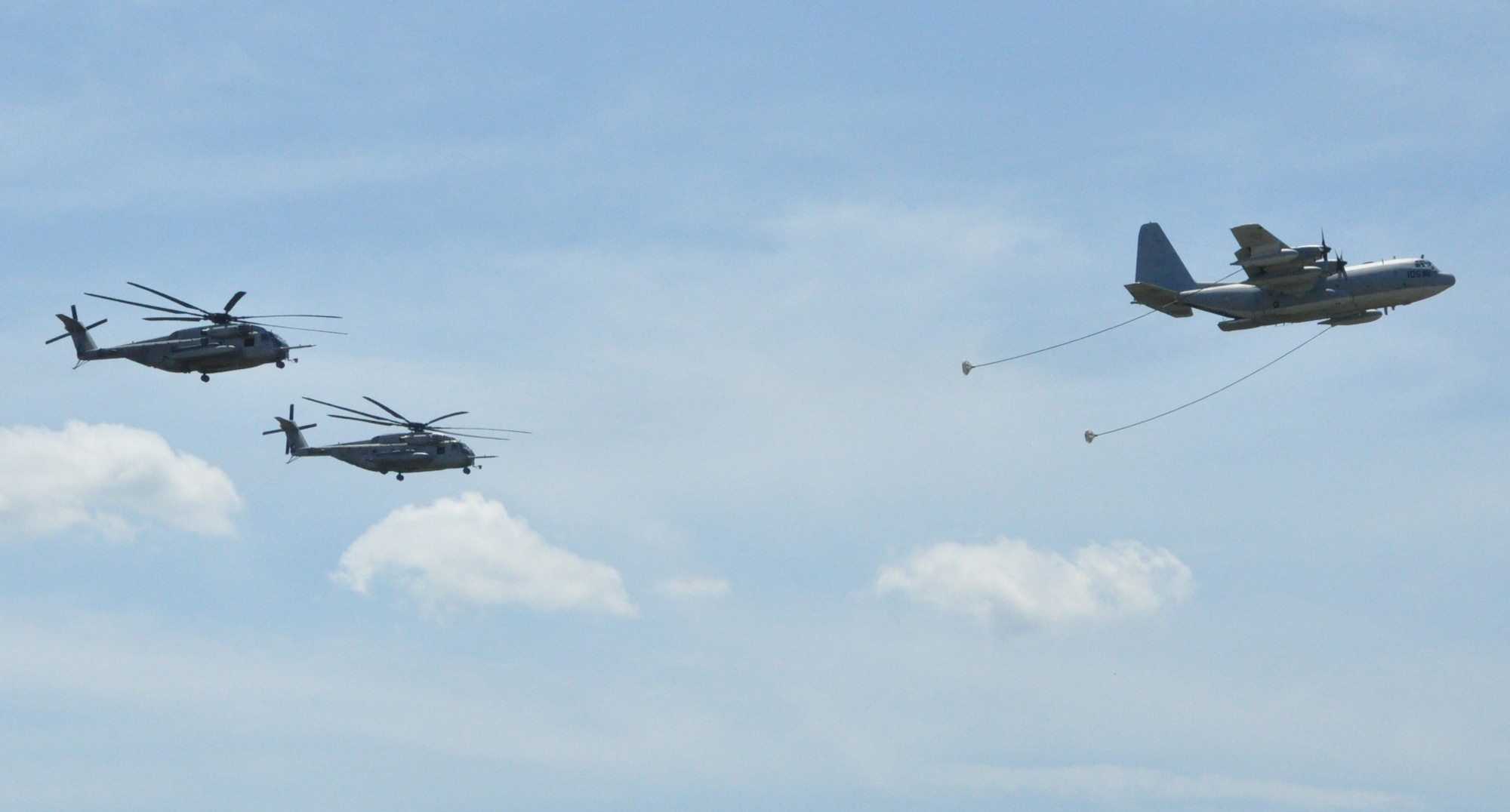 Two U.S. Marine Corps CH-53 Sea Stallion helicopters from U.S. Marine Corps Air Ground Task Force, Marine Aircraft Group 49, trail behind a C-130 Hercules aircraft in a simulated refueling exercise during the Joint Base McGuire-Dix-Lakehurst Open House and Air Show May 12. (U.S. Air Force photo by Pascual Flores/Released)