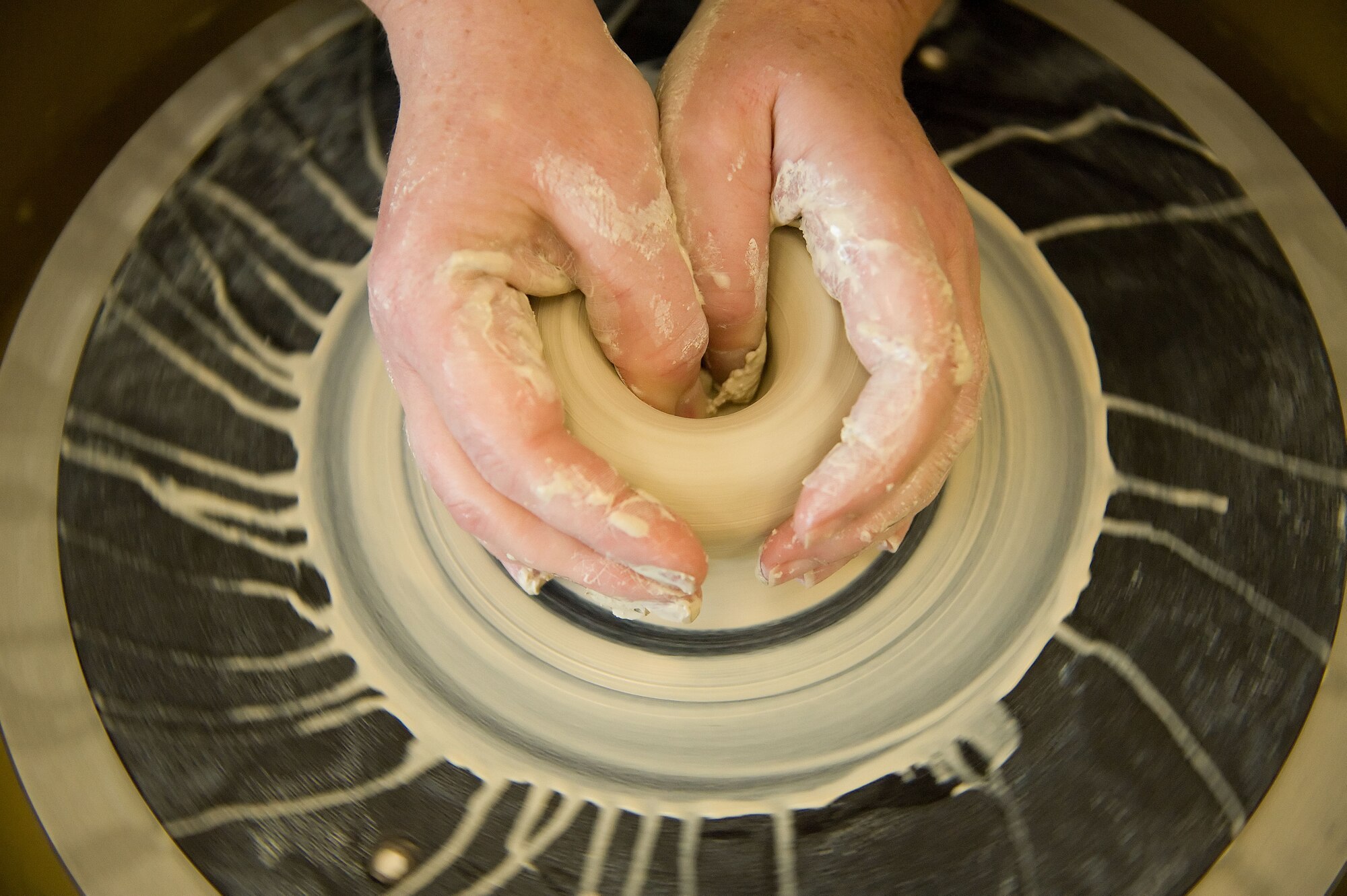 A member of the Arts and Crafts Center demonstrates the use of the pottery wheel May 9, 2011, at the A&CC on Dover Air Force Base, Del. The Arts and Crafts center offers pottery classes to service members and dependents. (U.S. Air Force photo by Adrian R. Rowan)