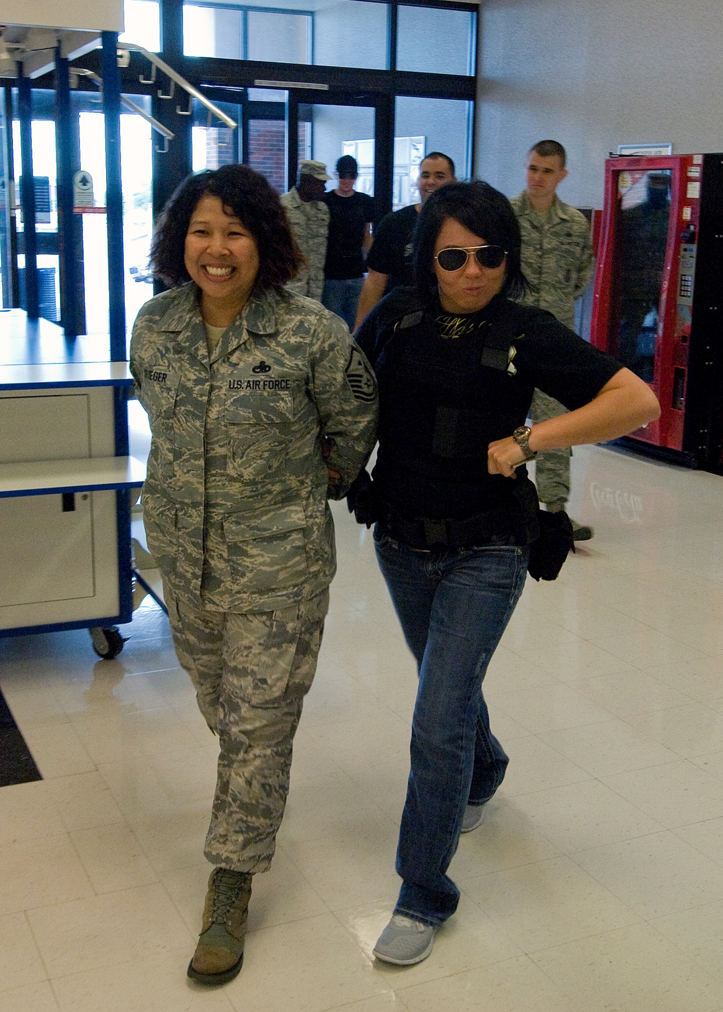 Staff Sgt. Jama Cohea, 7th Security Forces Squadron, escorts Master Sgt. Josephine Krieger, 7th Force Support Squadron first sergeant, to jail during a jail-and-bail fundraiser May 15, 2012, at Dyess Air Force Base, Texas. The fundraiser allowed airmen to have military and civilian personnel from Dyess  arrested and taken to the base exchange, where a make-shift prison cell awaited them. The prisoners were held for one minute for every dollar that was donated toward their arrest. The event was held during National Police Week, proclaimed by President John F. Kennedy in 1962, to honor those who have made the ultimate sacrifice. (U.S. Air Force photo by Airman 1st Class Damon Kasberg /Released)